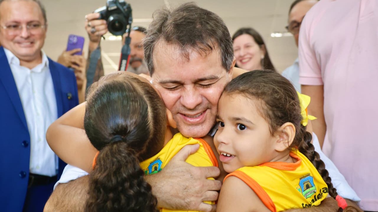 prefeito evandro abraça duas alunas